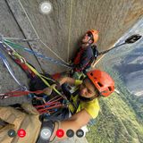 850 Klettermeter sind bereits geschafft: Am Standplatz hängt Caro North die Seile mit einem Karabiner in die Bohrhaken ein und sortiert das Material. Aus dem Rucksack von Tony Brown ragt der an der Stange befestigte Kamerawürfel.