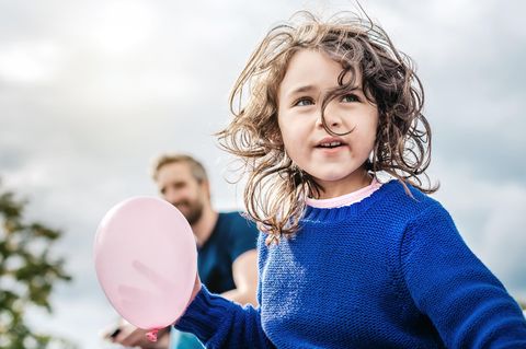 Mädchen mit rosa Luftballon schaut besorgt