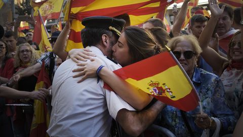 Eine Frau umarmt in Barcelona einen Polizisten der Guardia Civil
