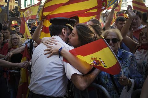 Eine Frau umarmt in Barcelona einen Polizisten der Guardia Civil