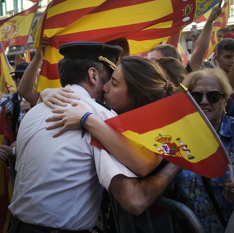 Eine Frau umarmt in Barcelona einen Polizisten der Guardia Civil