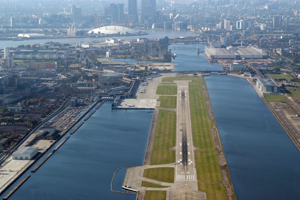 Die nur 1500 Meter lange Betonpiste im Hafenbecken. Im Hintergrund rechts die Ausstellungshallen der Messe ExCel und die weiße Kuppel des Millennium Dome an der Themse-Schleife. 