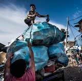 Jakarta, Indonesien  Die Hauptstadt ertrinkt im Müll und im Meer. Um etwa sieben Zentimeter sackt Jakarta jedes Jahr ab, weil die Grundwasserblasen im Boden ausgebeutet wurden, die die Stadt früher trugen. Hinzu kommen Unmengen Plastikmüll, die die lebenswichtigen Entwässerungskanäle verstopfen und so zum chronischen Hochwasser beitragen. Viele Leute werfen Flaschen und anderen Abfall einfach auf die Straße, wo er oft innerhalb von Minuten von anderen aufgesammelt und später an Wertstoffhändler verkauft wird.