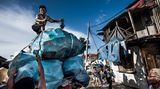 Jakarta, Indonesien  Die Hauptstadt ertrinkt im Müll und im Meer. Um etwa sieben Zentimeter sackt Jakarta jedes Jahr ab, weil die Grundwasserblasen im Boden ausgebeutet wurden, die die Stadt früher trugen. Hinzu kommen Unmengen Plastikmüll, die die lebenswichtigen Entwässerungskanäle verstopfen und so zum chronischen Hochwasser beitragen. Viele Leute werfen Flaschen und anderen Abfall einfach auf die Straße, wo er oft innerhalb von Minuten von anderen aufgesammelt und später an Wertstoffhändler verkauft wird.