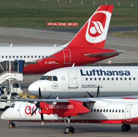 Flugzeuge auf dem Rollfeld in Berlin-Tegel. Im Vordergrund eine Bombardier Dash 8 der Luftverkehrsgesellschaft Walter, dahinter ein Airbus der Lufthansa und von Air Berlin. 