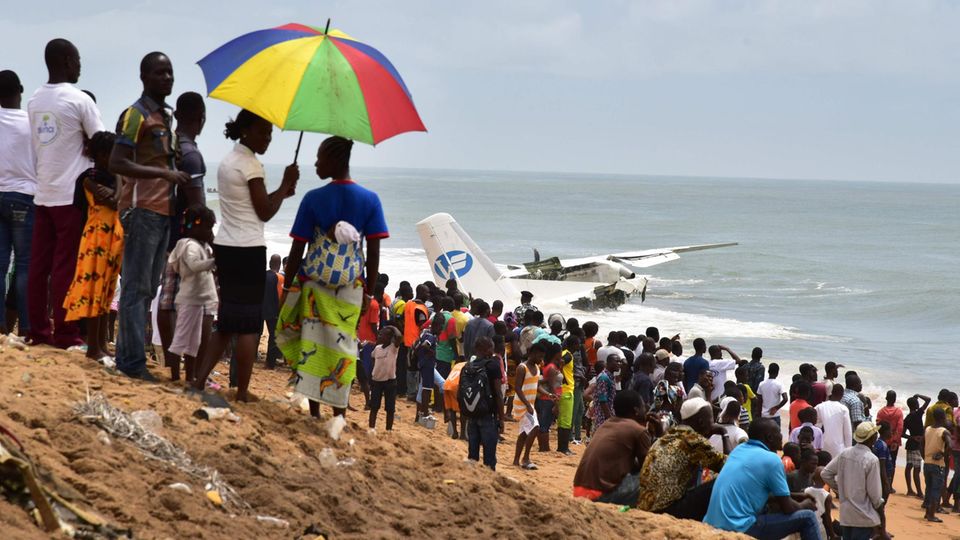 Frachtflugzeug stürzt an der Elfenbeinküste ab Schaulustige stehen am Strand von Port-Bouet in Abidjan und beobachten die Bergungsarbeiten