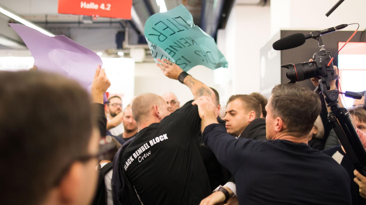 Plakate werden zerrissen und zerknüllt. Die Demonstranten rufen mit Sprechchören wie "Nazis raus" gegen die Lesung an. Höckes Anhänger antworten mit "Jeder hasst die Antifa". 