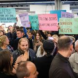 Demonstranten halten Protestplakate hoch. Sie tragen die Aufschriften "Ihr könnt nicht schreiben. Ihr könnt nur hetzen" oder "Meinungsfreiheit Ja! Menschenverachtung Nein!".