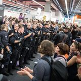 Demonstranten verhindern auf der Buchmesse in Frankfurt am Main die Fortsetzung einer Veranstaltung eines rechten Verlages. Polizisten bilden dabei eine Kette.