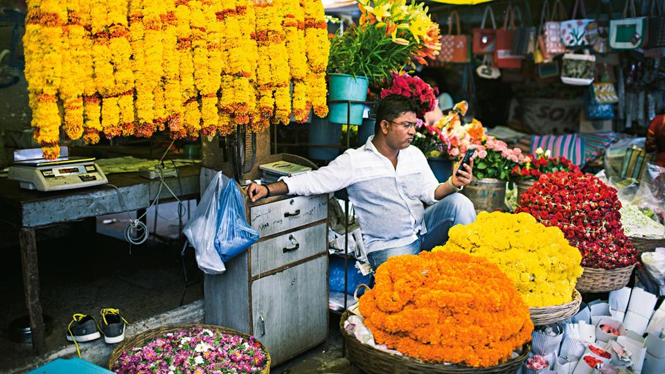 Goa im Süden Indiens: Konsum und Karma: Ein Blumenhändler auf dem Markt von Panaji vertreibt sich die Zeit Konsum und Karma: Ein Blumenhändler auf dem Markt von Panaji vertreibt sich die Zeit