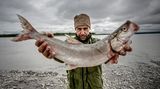 Till Lindemann posiert mit einem gefangenen Fisch