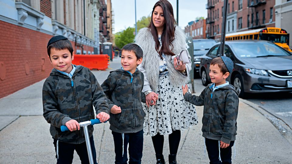 Orthodoxe jüdische Glaubensgemeinschaft: Devorah Bukiet mit dreien ihrer vier Söhne in Brooklyns Viertel Crown Heights. Die Frauen der Chabad kleiden sich modern. Aber auch sie tragen, wie alle anderen Chassidim-Frauen, Perücken. In den Bussen der Gemeinde sitzen die Menschen nach Geschlecht getrennt Devorah Bukiet mit dreien ihrer vier Söhne in Brooklyns Viertel Crown Heights. Die Frauen der Chabad kleiden sich modern. Aber auch sie tragen, wie alle anderen Chassidim-Frauen, Perücken. In den Bussen der Gemeinde sitzen die Menschen nach Geschlecht getrennt