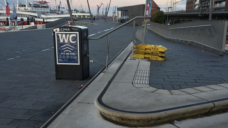 Hamburg Baumwall Das ganze Elend auf einen Blick: Die weißen Betontreppen am bereits fertig gestellten Abschnitt sind total vermoost, der Mülleimer mit dem WC-Schild ist mit einer Kette befestigt. Schick geht anders.