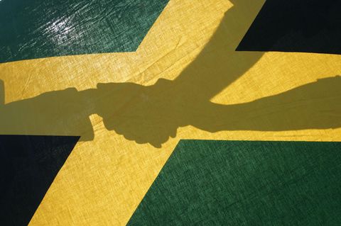 Händeschütteln - Schattenspiel unter einer Jamaika-Flagge