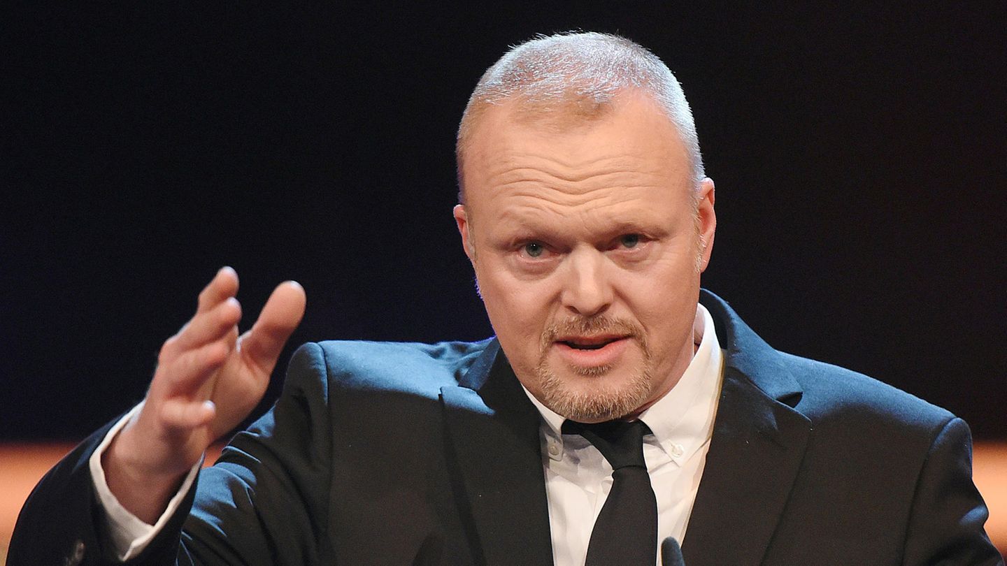 Ex-Entertainer Stefan Raab gestikuliert mit der rechten Hand. Er trägt einen schwarzen Anzug und eine schwarze Krawatte.