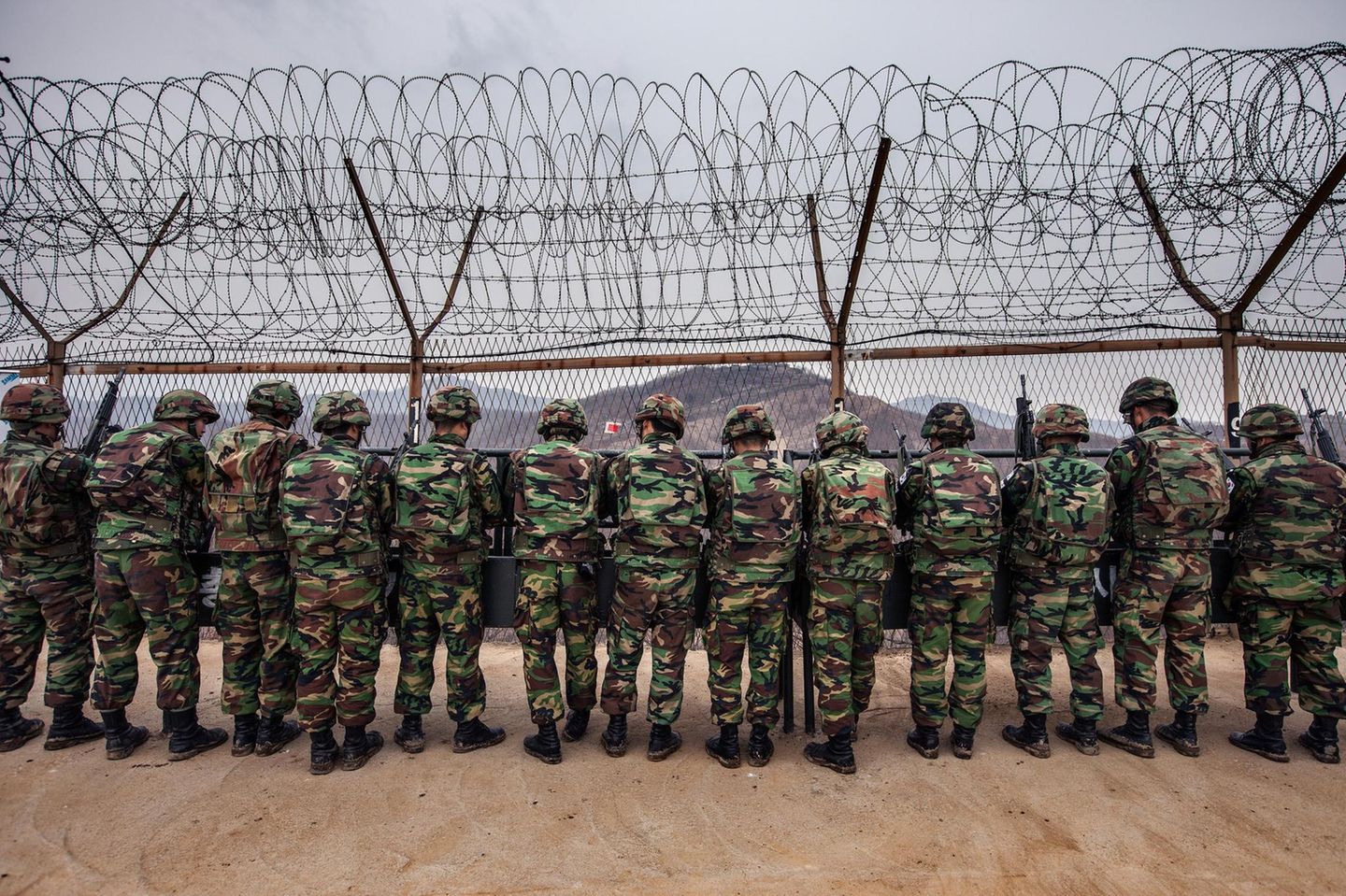Schwer bewaffnet: Soldaten auf der Südseite schauen durch den Zaun nach Norden.