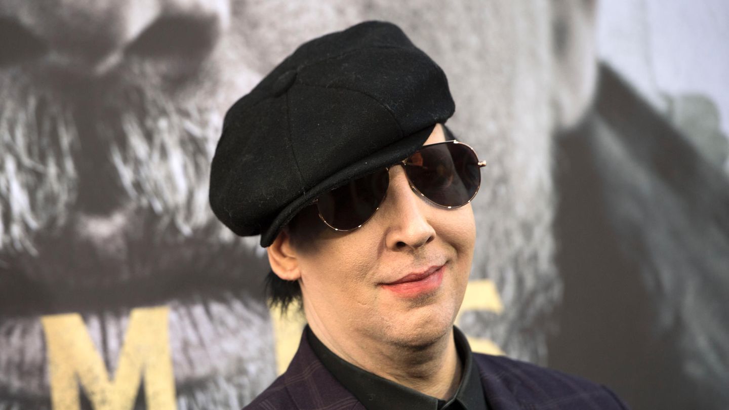 Mit Schiebermütze und Sonnenbrille lächelt Brian Warner alias Marilyn Manson in die Kamera