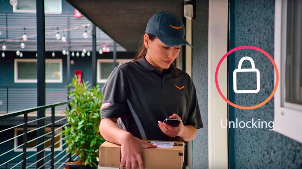 Eine Amazon-Mitarbeiterin öffnet mit ihrem Smartphone die Tür eines Kunden