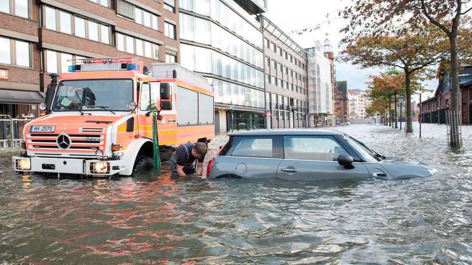 Am Hamburger Fischmarkt steht ein Auto im Wasser. Am Sonntagvormittags wurde es zwar sonnig in der Hansestadt, es gab aber eine Sturmflut.