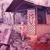 Ein Kind spielt mit dem Zweig eines Bananen-Baumes. Die Maske war ein Geschenk der Fotografin zu Halloween. Dem Junge gefiel die Maskierung so sehr, dass er sie auch an den darauffolgenden Tagen trug.