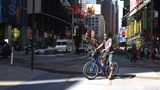 Broadway – Times Square  Ich hatte Angst vor dem Broadway, aber ich merke gleich: Der Broadway ist mein Freund. Ein dicker Fahrradstreifen säumt den ehemaligen Indianerpfad, der Manhattan diagonal durchschneidet. Ich gewinne an Sicherheit, verschmelze mit dem Metropolenwahnsinn um mich herum. Ich beobachte die radfahrenden New Yorker, imitiere sie. Bei Rot über die Fahrradampel, auch wenn dort ein Polizeiauto parkt? No problem. Fahren auf dem Bürgersteig? No way! Das Menschengewusel wird dichter, das neonfarbene Reklameblinken schriller, ich umkurve einen Kran, der den Fahrradweg blockiert, dann lande ich in der totalen Reizüberflutung. Der Duft des heißen Wurstwassers der Hot-Dog-Stände vermischt sich mit dem gerösteter Mandeln und der muffigen Luft der U-Bahn-Schächte. Micky Maus winkt mir zu. Eine Freiheitsstatue will mich umarmen. Die verkleideten Straßenkünstler geben sich alle Mühe, den Touristen das Kleingeld zu entlocken. Mein Klingeln geht im Großstadtlärm unter. Ich gebe auf und steige ab. Times Square. Surreal, wie eine Comicverfilmung der Wirklichkeit. Ich schiebe das Fahrrad einmal quer durch die Menschenmenge – und bin auf schätzungsweise 150 Selfies gebannt. 