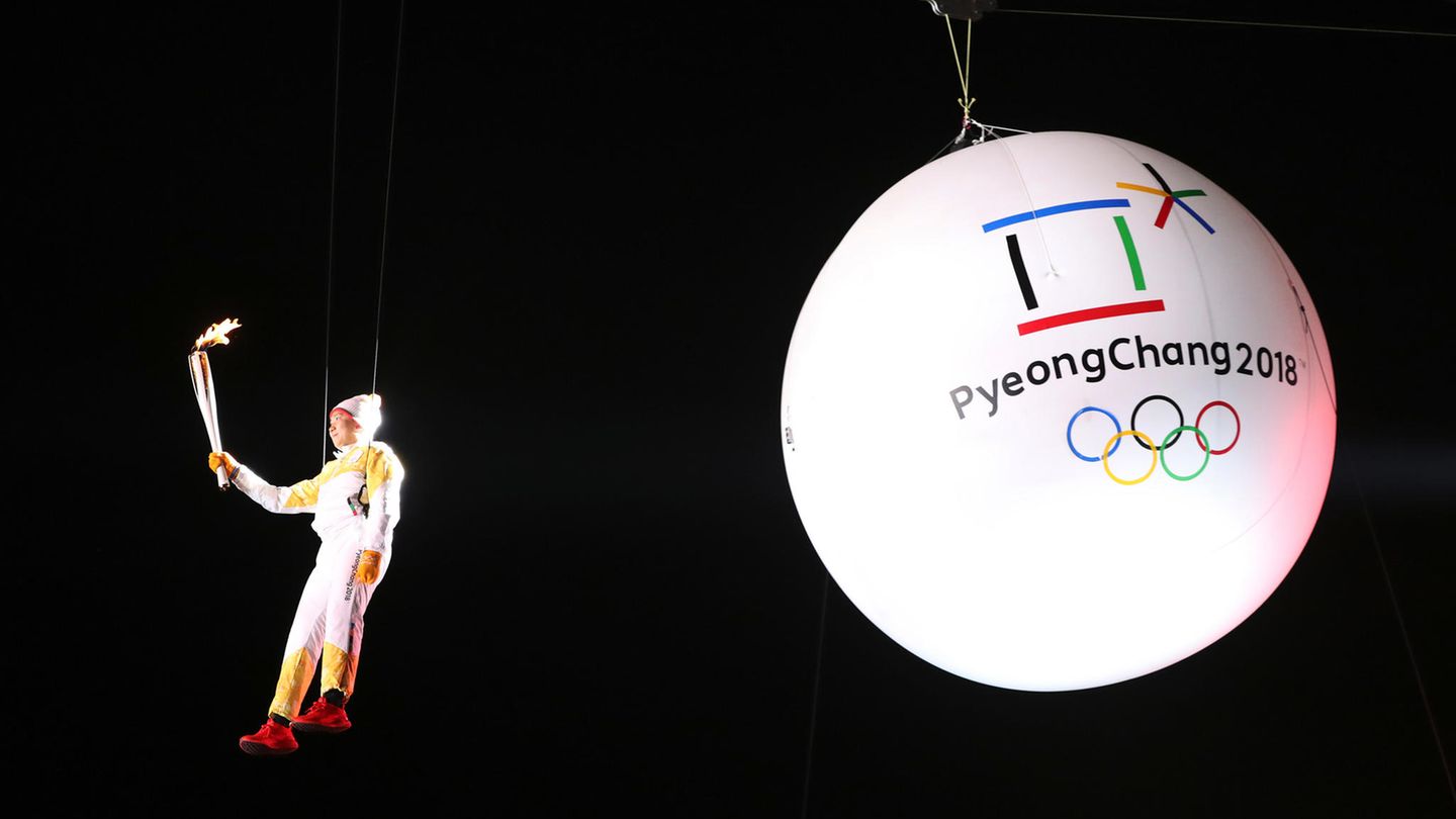 Der Südkoreaner Ryu Seung-min schwebt mit der olympischen Flamme in der Hand an einem Seil