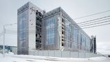 Eine vom Wind zerzauste, auf Kunstoffbahnen aufgedruckte Fassade in der russischen Millionenmetropole Ufa.