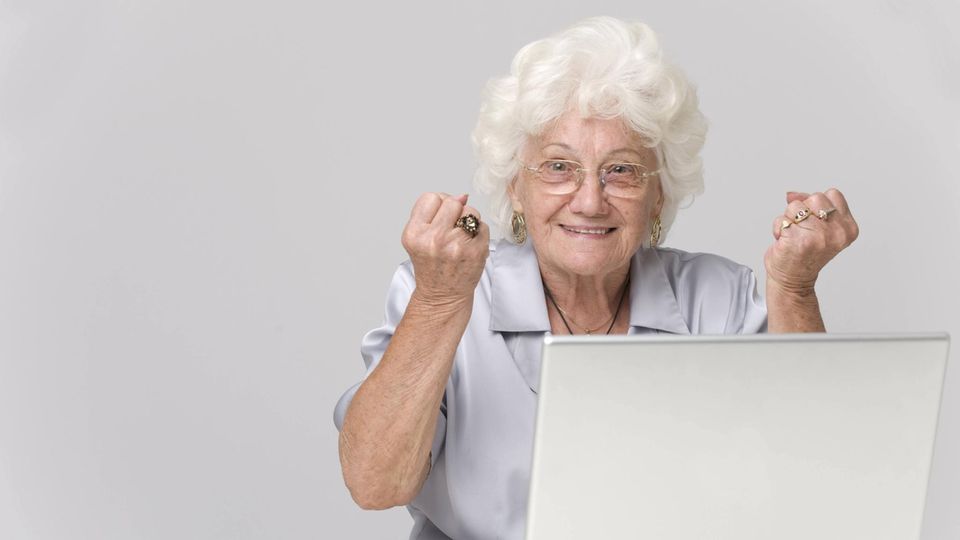 Eine Omi freut sich vor dem Computer über ihren Geburtstag