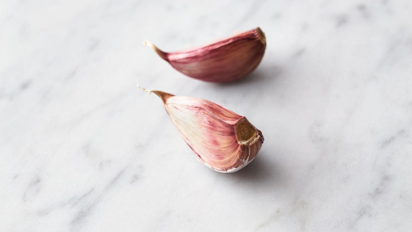 Inzwischen den Knoblauch schälen, in feine Scheibchen schneiden und in einer großen beschichteten Pfanne in ½ EL Olivenöl bei mittlerer bis starker Hitze 1 Minute anbraten.