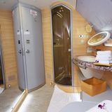 Wie ein Raumschiff: Durch einen bodentiefen Spiegel wirkt das fliegende Badezimmer noch größer. Rechts neben der Tür zur Kabine ist die gläserne Duschkabine platziert.