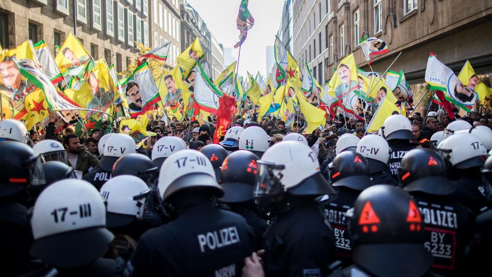 Polizisten blockieren in Düsseldorf eine Kurden-Demonstration, bei der verbotene Fahnen von Öcalan gezeigt werden