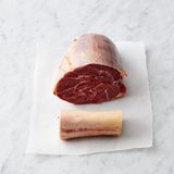 Den Backofen auf 160 °C vorheizen. Einen großen flachen, backofenfesten Schmortopf und eine große beschichtete Pfanne bei hoher Temperatur erhitzen. Das Fleisch in 5 cm große Würfel schneiden und mit reichlich schwarzem Pfeffer sowie 1 Prise Meersalz mischen. Zusammen mit dem Knochen in der heißen Pfanne ohne Fett 8 Minuten anbraten.