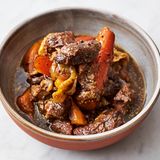 Das Gericht im heißen Ofen zugedeckt 4 Stunden garen, bis das Fleisch fast zerfällt; falls nötig, den Bratensatz mit 1 Schuss Wasser ablöschen. Mit Salz und Pfeffer abschmecken und servieren.