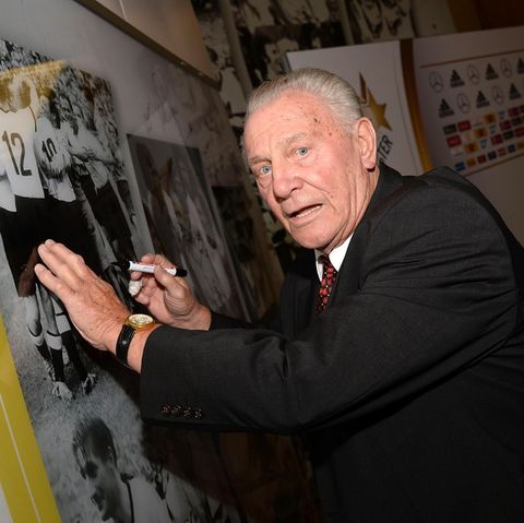 Hans Schäfer setzt sein Autogramm auf einem alten Foto der Fußball-Nationalmannschaft