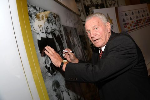Hans Schäfer setzt sein Autogramm auf einem alten Foto der Fußball-Nationalmannschaft