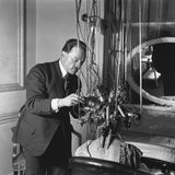 Sieht bedrohlicher aus als es ist: Ein Frisör verpasst einer Kundin eine Dauerwelle um 1921. 