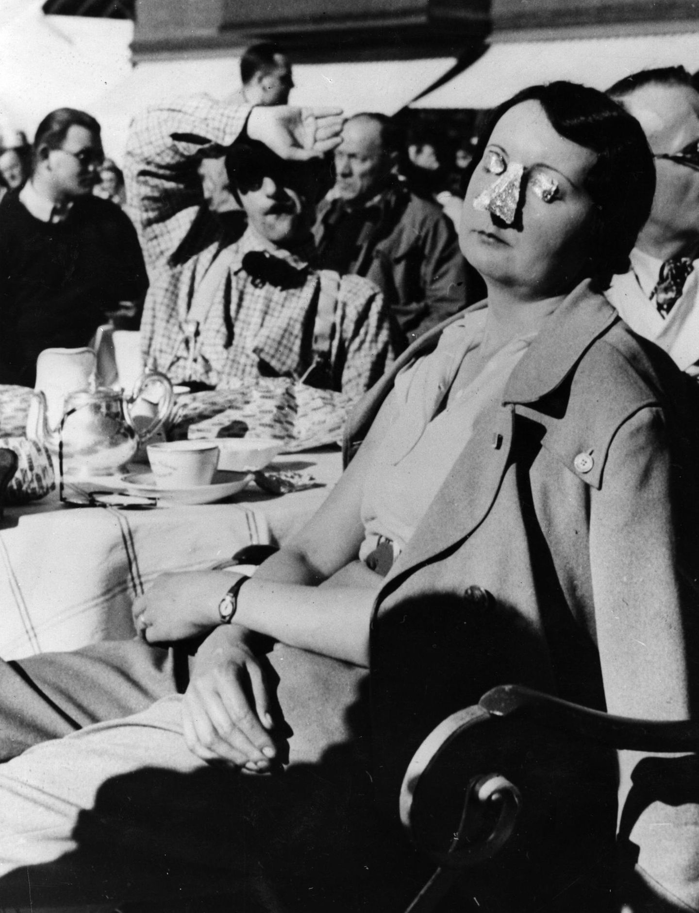 Zeitgemäßer ist diese Dame an der Côte d’Azur unterwegs: Sie schützt die Haut ihrer Augen und Nase mit Silberpapier vor der schädlichen UV-Strahlung der Sonne. Diesen Job erledigt heutzutage zum Glück Sonnencreme.
