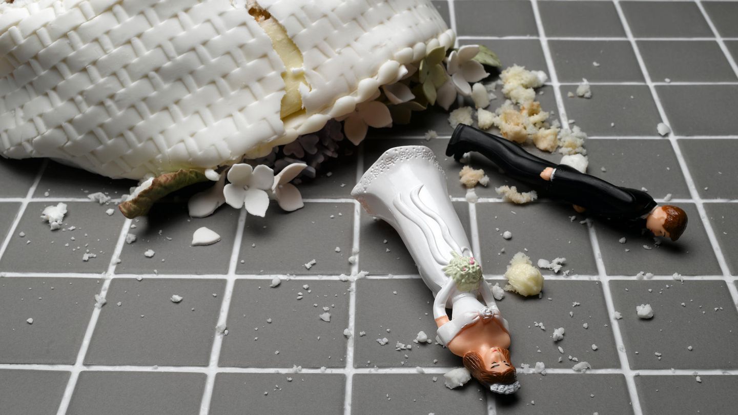 Eine Hochzeitstorte liegt zerstört auf deinem gekachelten Boden