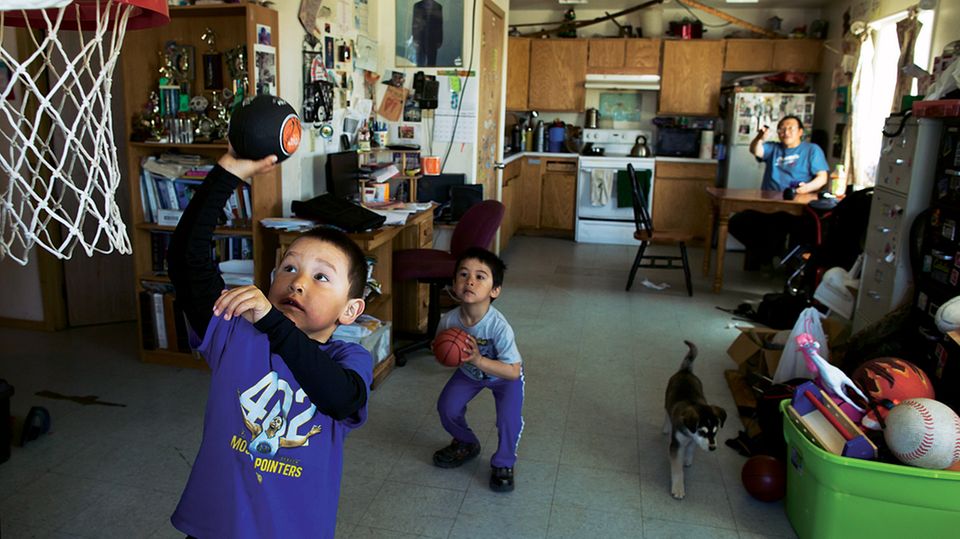 Merle Apassingok, ein Onkel von Chris, beobachtet seine Enkel zu Hause beim Spielen. Die meisten Familien leben in einfachen Holzhäusern