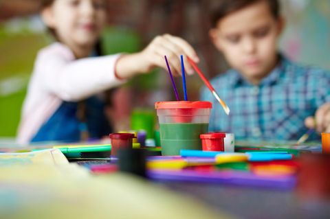 Zwei Kinder sitzen am Tisch und basteln