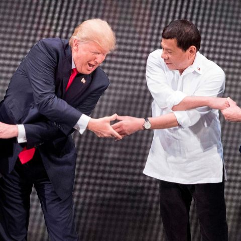 US-Präsident Donald Trump und der philippinische Präsident Rodrigo Duterte geben sich mit Armen über Kreuz die Hand