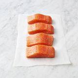 Das Lachsfilet in die Ingwermischung auf das Brett legen und in 1 cm große Stücke schneiden. Die Hälfte an den Rand schieben und den Rest weiter zerhacken, bis alles ganz fein ist, fast wie eine Paste. Anschließend die gröberen Stücke wieder untermengen und alles mit Meersalz und schwarzem Pfeffer würzen. Die Masse zu vier Frikadellen formen, etwa 2 cm dick.  In einer großen beschichteten Pfanne 1 EL Olivenöl bei mittlerer bis hoher Temperatur erhitzen. Die Frikadellen hineinlegen, von jeder Seite 2 Minuten braten, bis sie schön gebräunt sind.