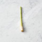 Das Zitronengras auf der Arbeitsfläche weich klopfen und von der harten äußeren Blattschicht befreien.