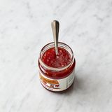 Die Chilikonfitüre über die Frikadellen löffeln und 1 Schuss Wasser in die Pfanne gießen. Die Pfanne vom Herd nehmen und sanft schwenken und kreisen lassen, um die Chilisauce über die Frikadellen zu ziehen.