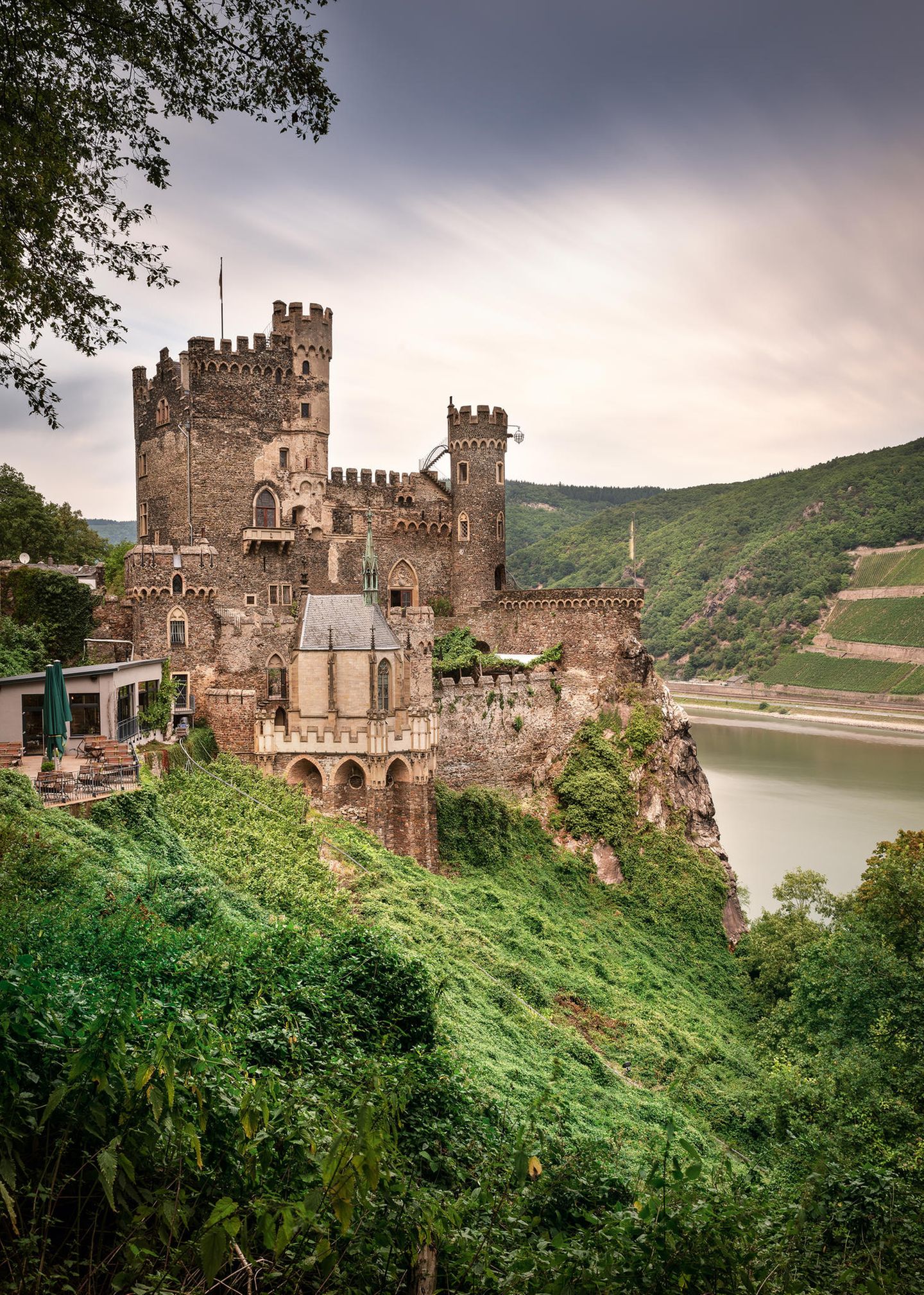 Kulturlandschaft Oberes Mittelrheintal  Auf dem 67 Kilometer langen Rheinabschnitt zwischen Bingen und Koblenz fließt der Strom durch das Rheinische Schiefergebirge. An den steilen Hängen gedeihen seit Jahrhunderten Reben, auf den Felsvorsprüngen stehen Burgen wie die Burg Rheinstein auf dem Foto. Nicht weit davon soll sich die Loreley-Sage zugetragen haben - Rheinromatik pur.  Infos: welterbe-mittelrhein.de