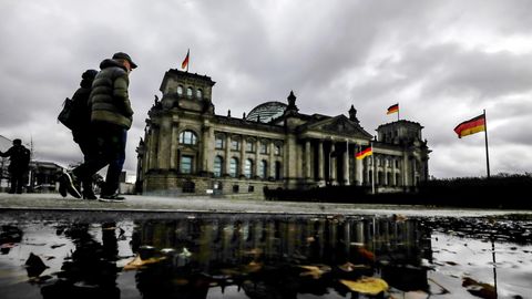 Dunkle Wolken hängen über dem Reichstagsgebäude, dem Sitz des Deutschen Bundestags