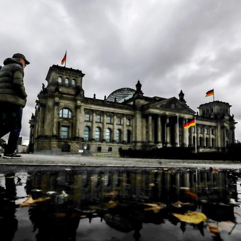 Dunkle Wolken hängen über dem Reichstagsgebäude, dem Sitz des Deutschen Bundestags