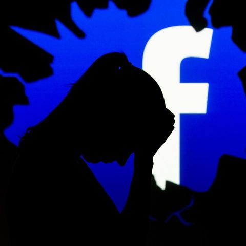 Der Schattenriss einer besorgten Frau ist vor dem Facebook-Logo zu sehen