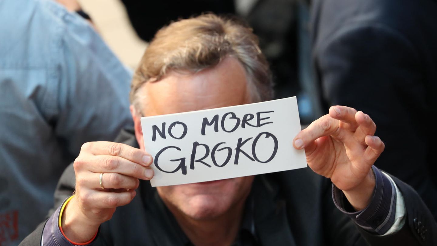 Ein Mann hält auf der SPD-Wahlparty ein Schild mit der Aufschrift "No More GroKo" vors Gesicht