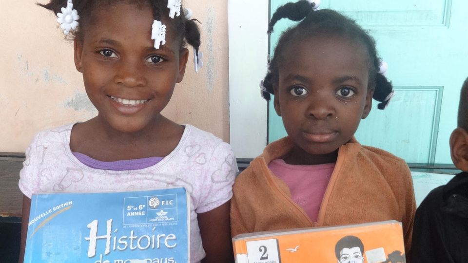 Die Mädchen freuen sich über ihre neuen Schulbücher Die Mädchen freuen sich über ihre neuen Schulbücher
